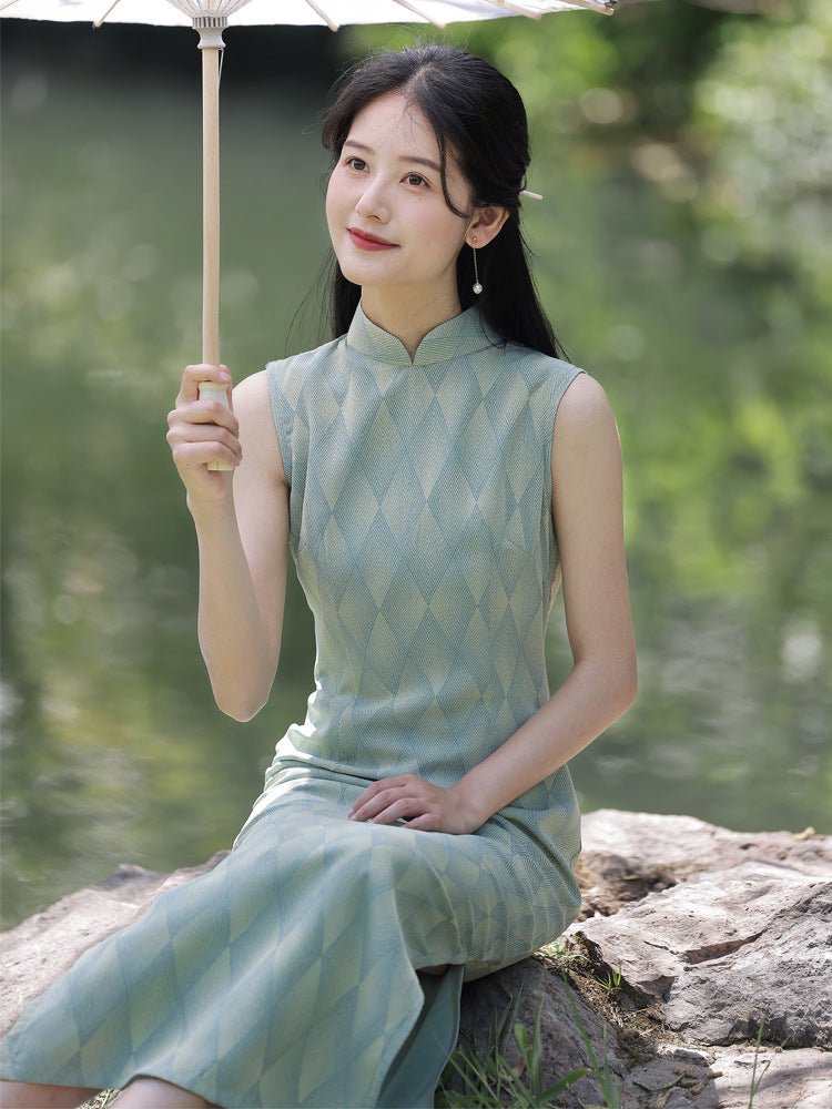 Lady in a light green cheongsam holding a paper fan, seated near a tranquil pond.