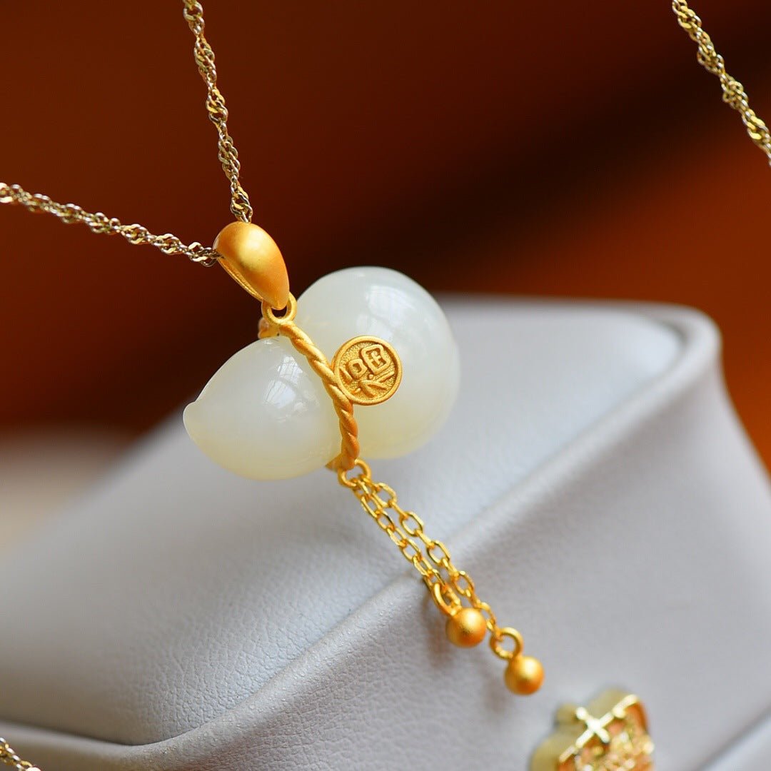 Detailed view of jade pendant and tassel gently arranged on ivory fabric – quiet, poetic composition