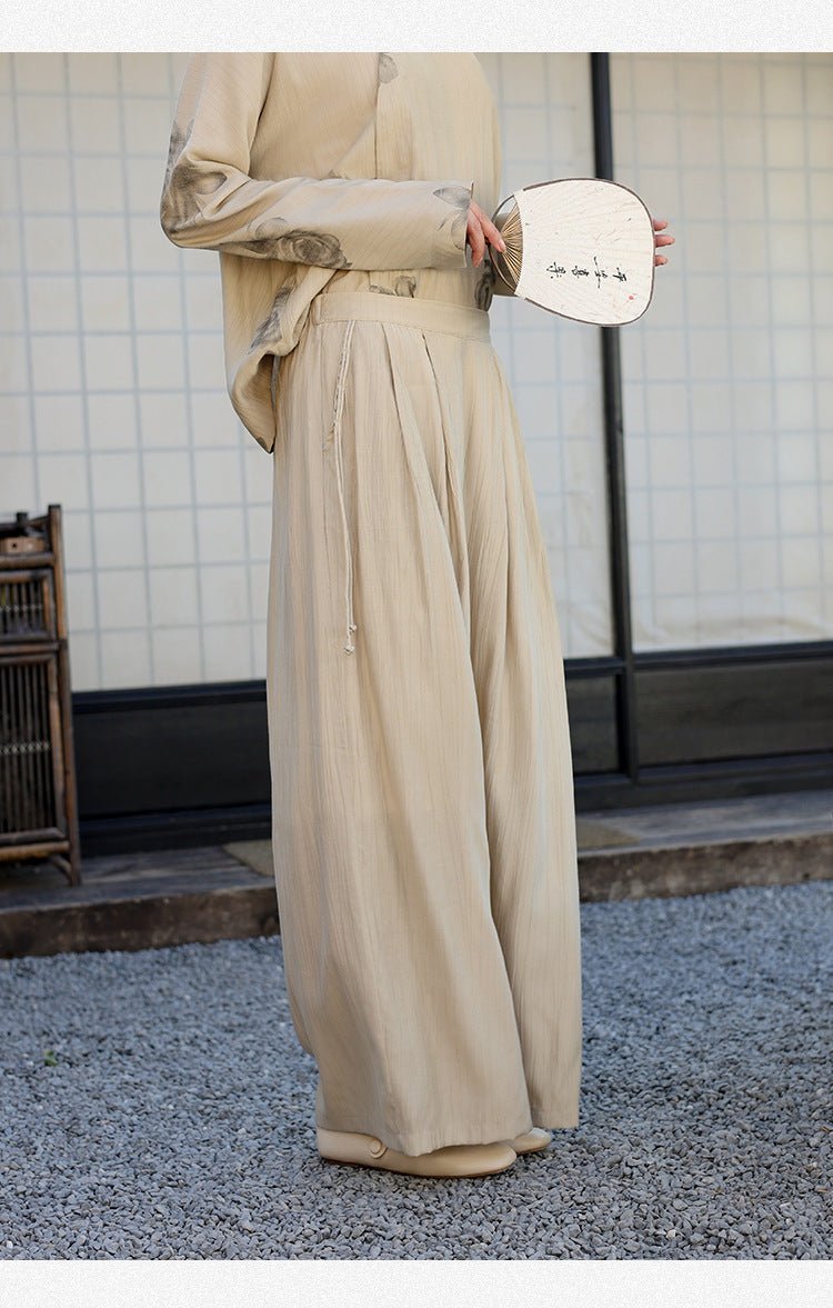 Beige cotton trousers with a gathered waist – side view of relaxed movement under soft daylight
