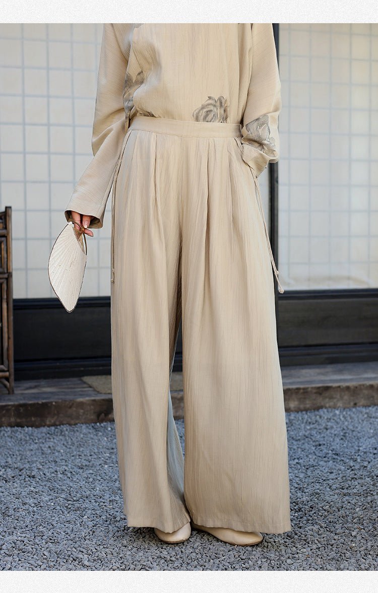 Loose-fit beige trousers captured mid-step – soft folds and a grounded sense of ease