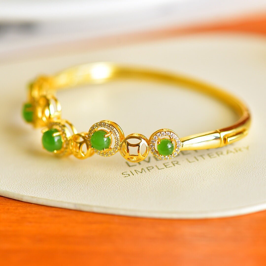 Close-up of a golden bracelet with multiple round jade stones, glowing under warm light.