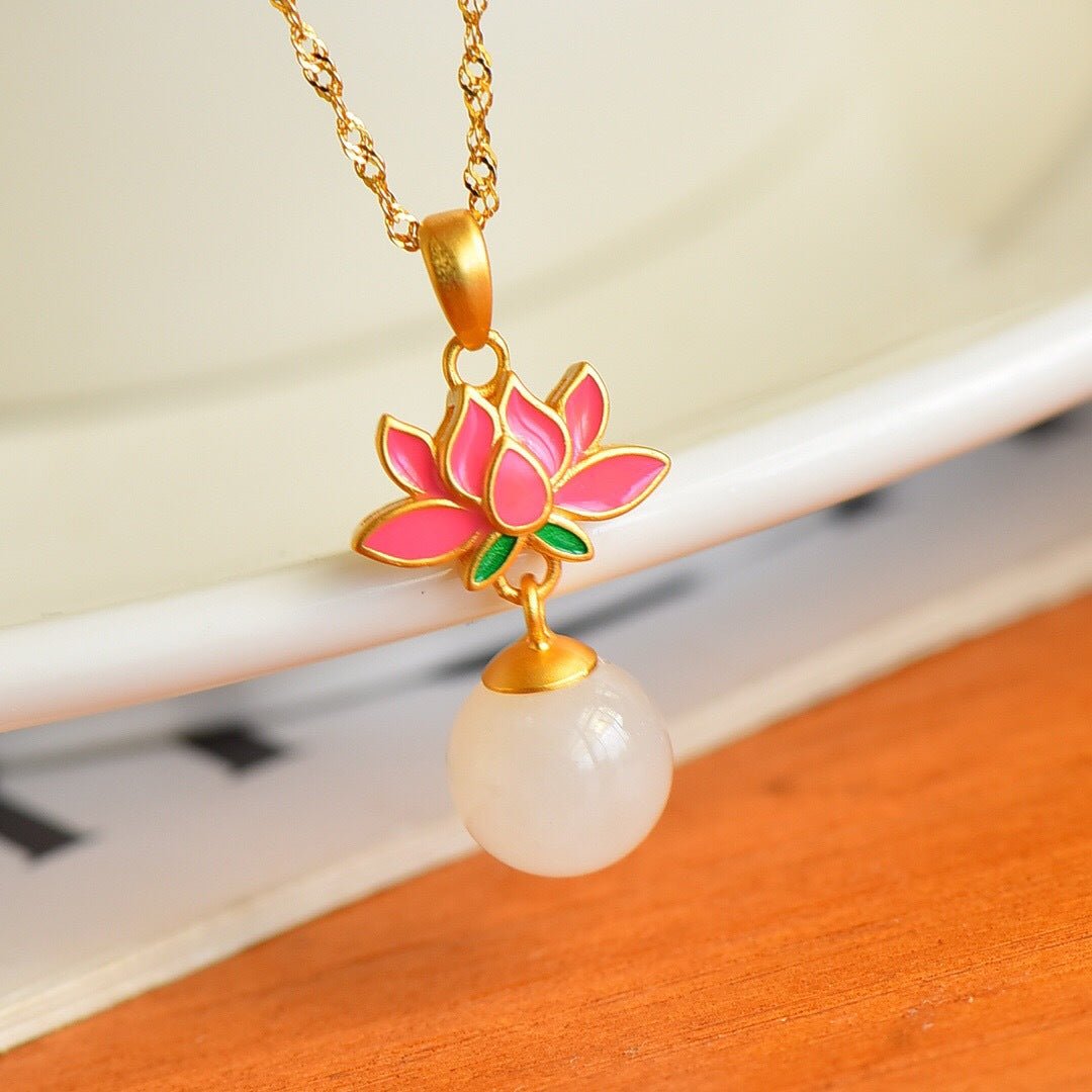 Golden lotus necklace with white jade pendant draped over an ivory curve – graceful everyday piece