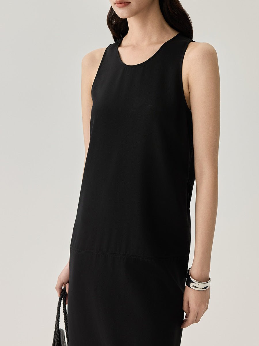Close-up of a woman wearing a black spaghetti strap dress, showing neckline and texture details.