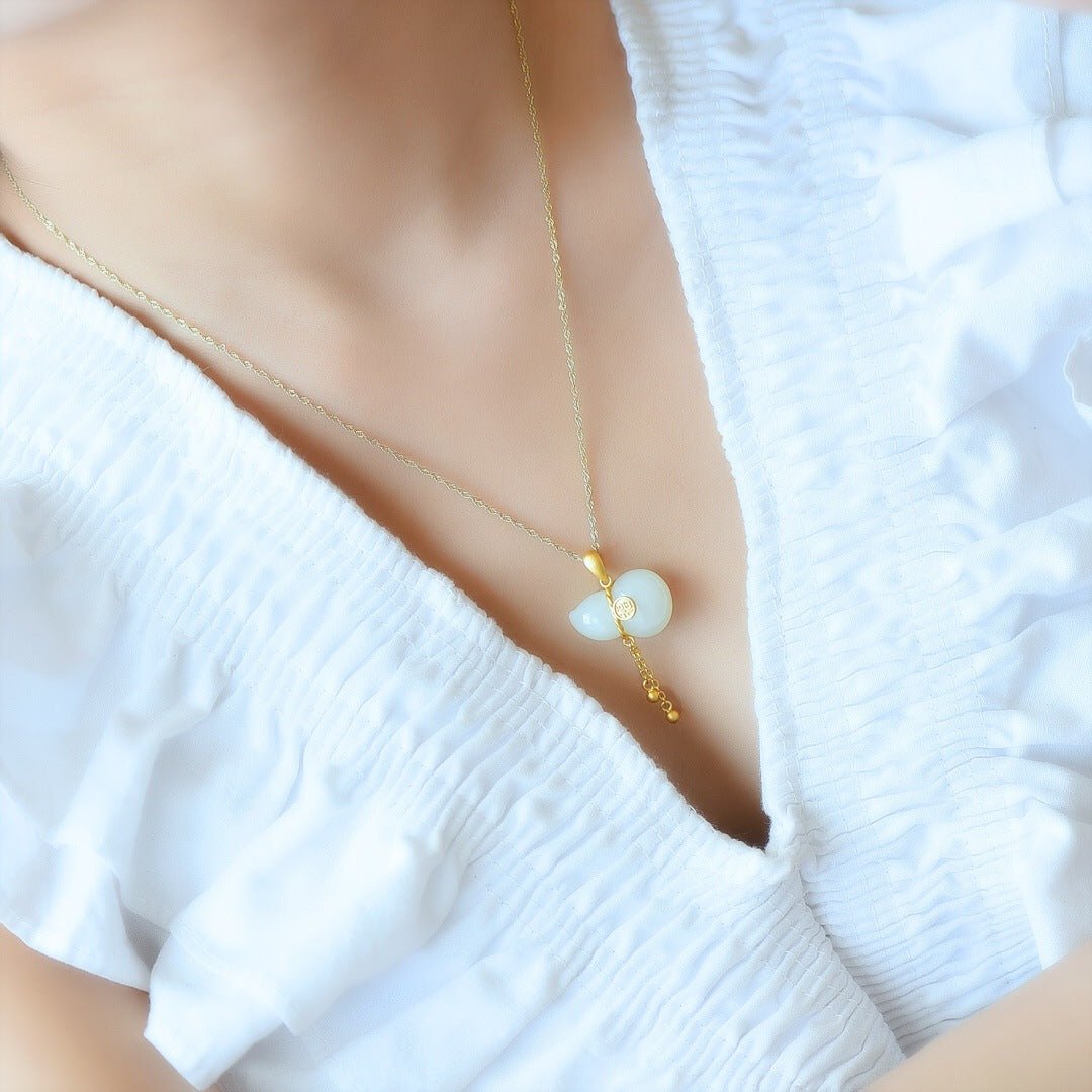Model wearing white jade gourd necklace – gold tassel resting just above the heart, serene and elegant
