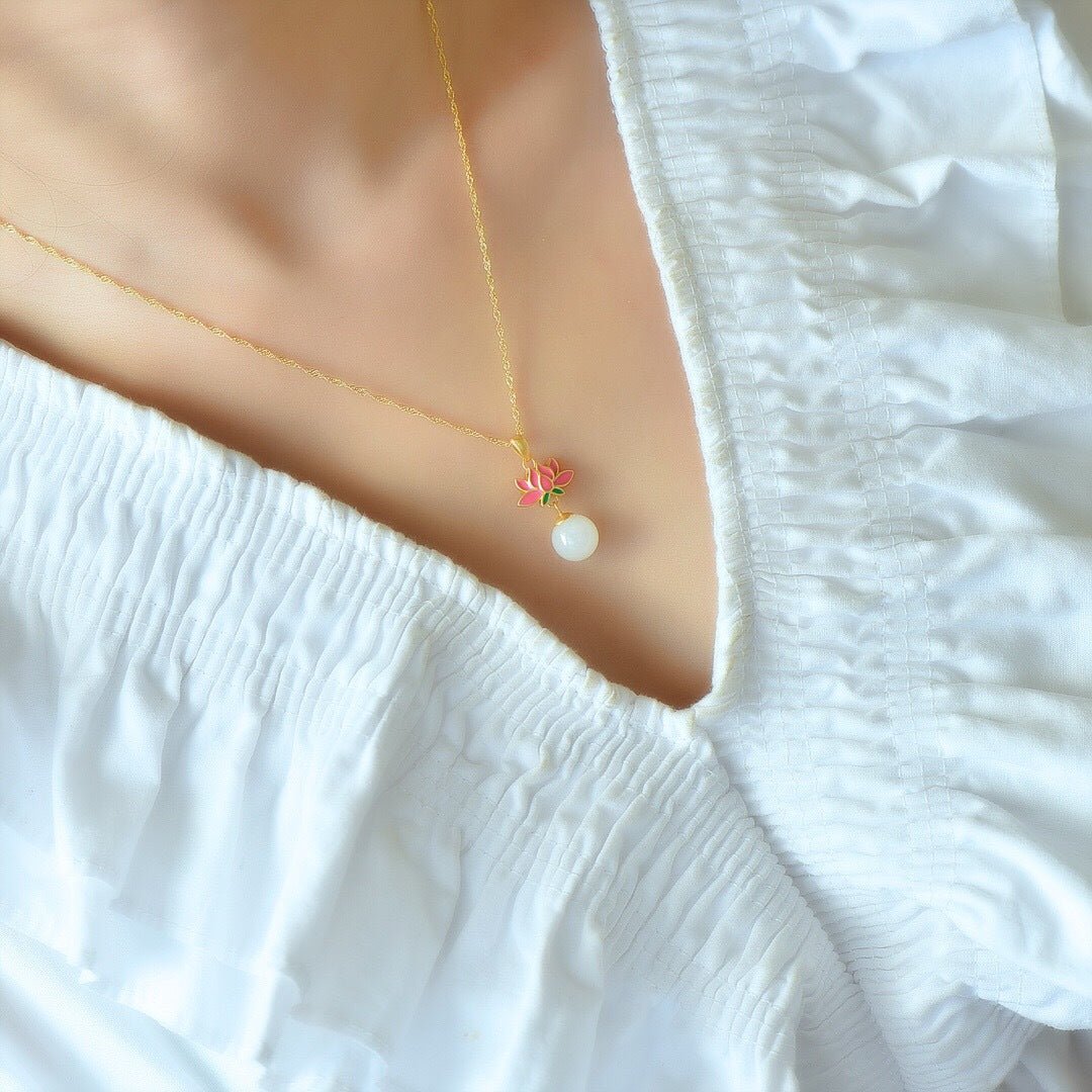 Model wearing lotus pendant on a soft neckline – quiet gold resting close to the heart