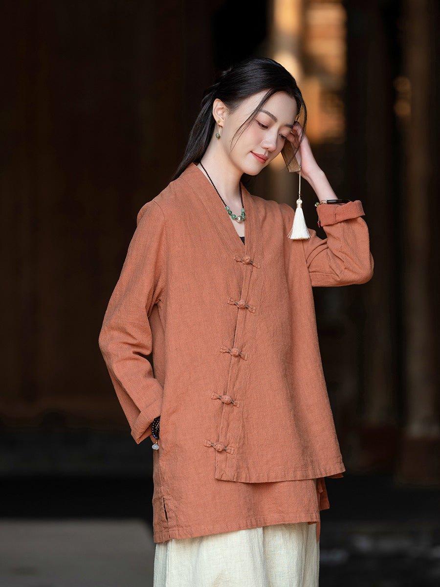 Model wearing a rust-colored Han-style shirt with mandarin collar, gently touching her sunglasses outdoors.