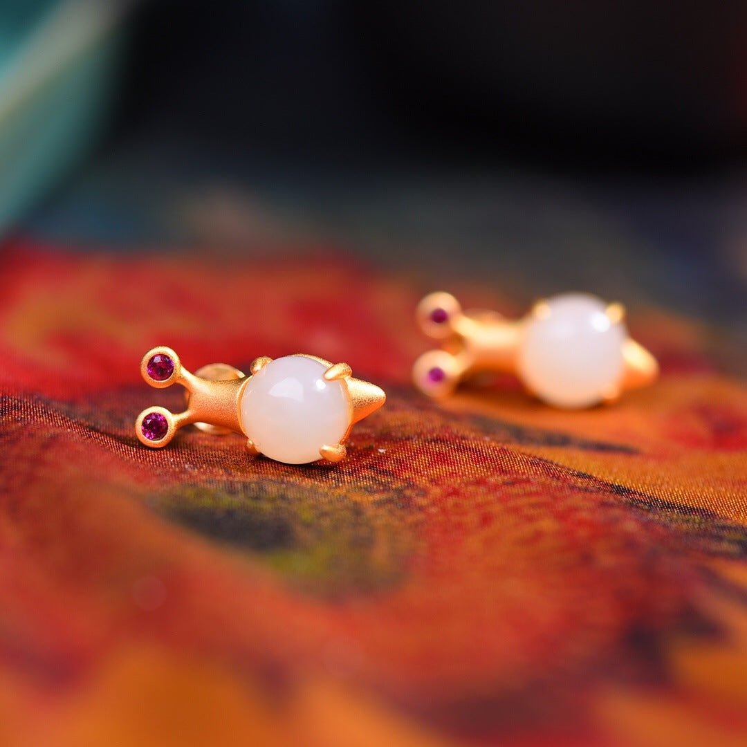 Adorable white jade mouse stud earrings with gold accents and tiny gemstone eyes — playful and refined.