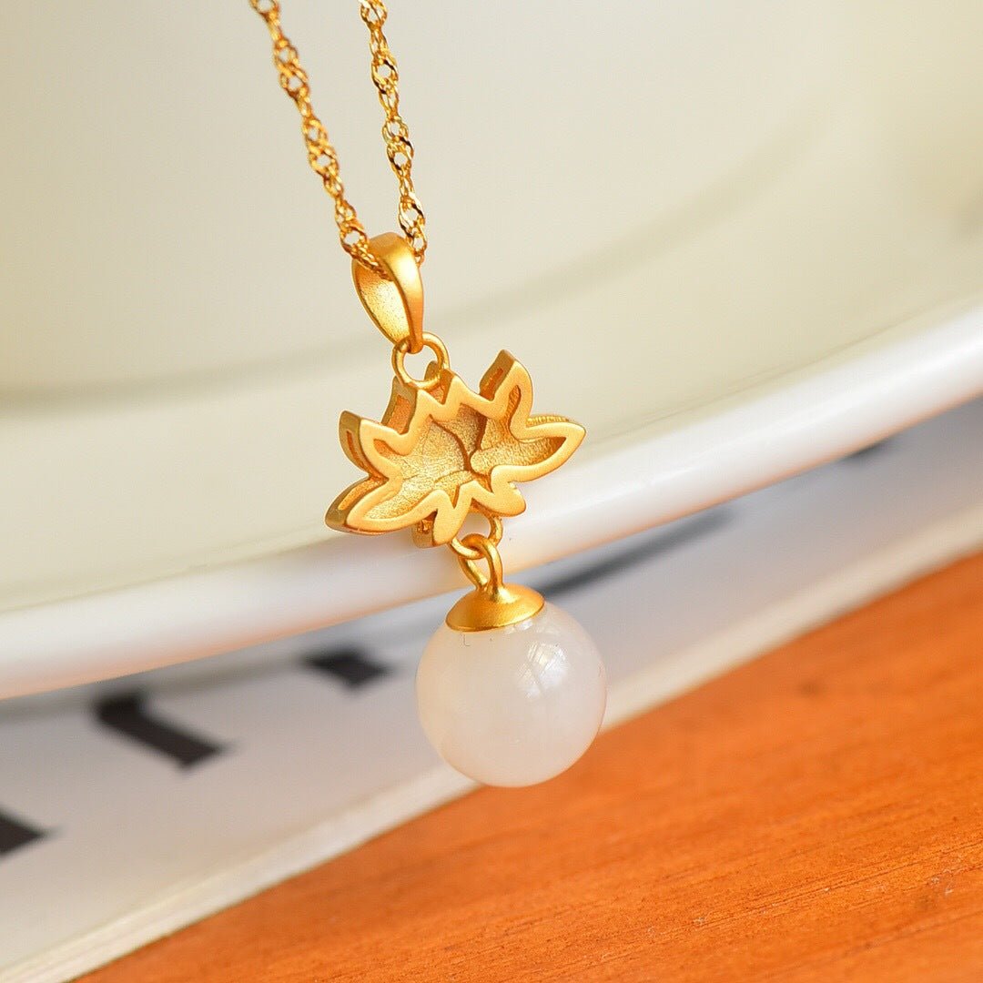 Close-up of the lotus charm and gold leaves – warm lighting highlights fine textures and craftsmanship