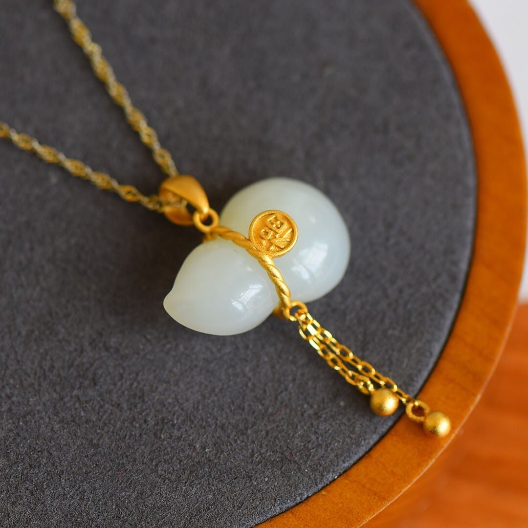 White jade gourd resting on charcoal fabric with golden glow – contrast of purity and richness