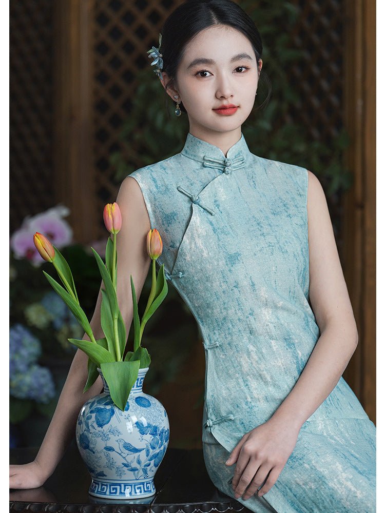 Poised lady in a blue-green cheongsam standing by a traditional cabinet, framed by classical decor.