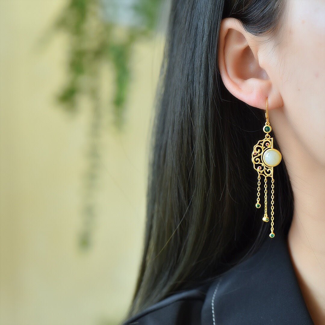 Model wearing long tassel jade earrings – gold strands swaying softly against dark hair