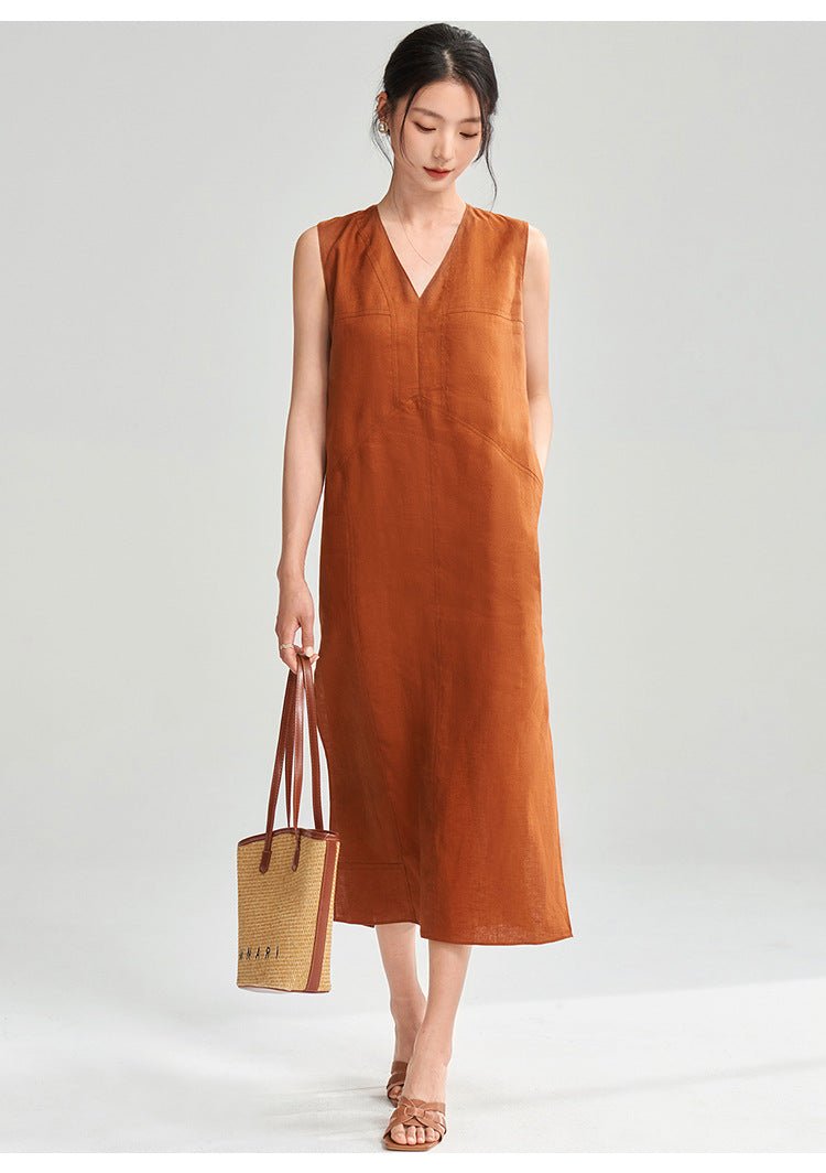 Full-body view of model holding a bag – wearing minimalist rust midi dress