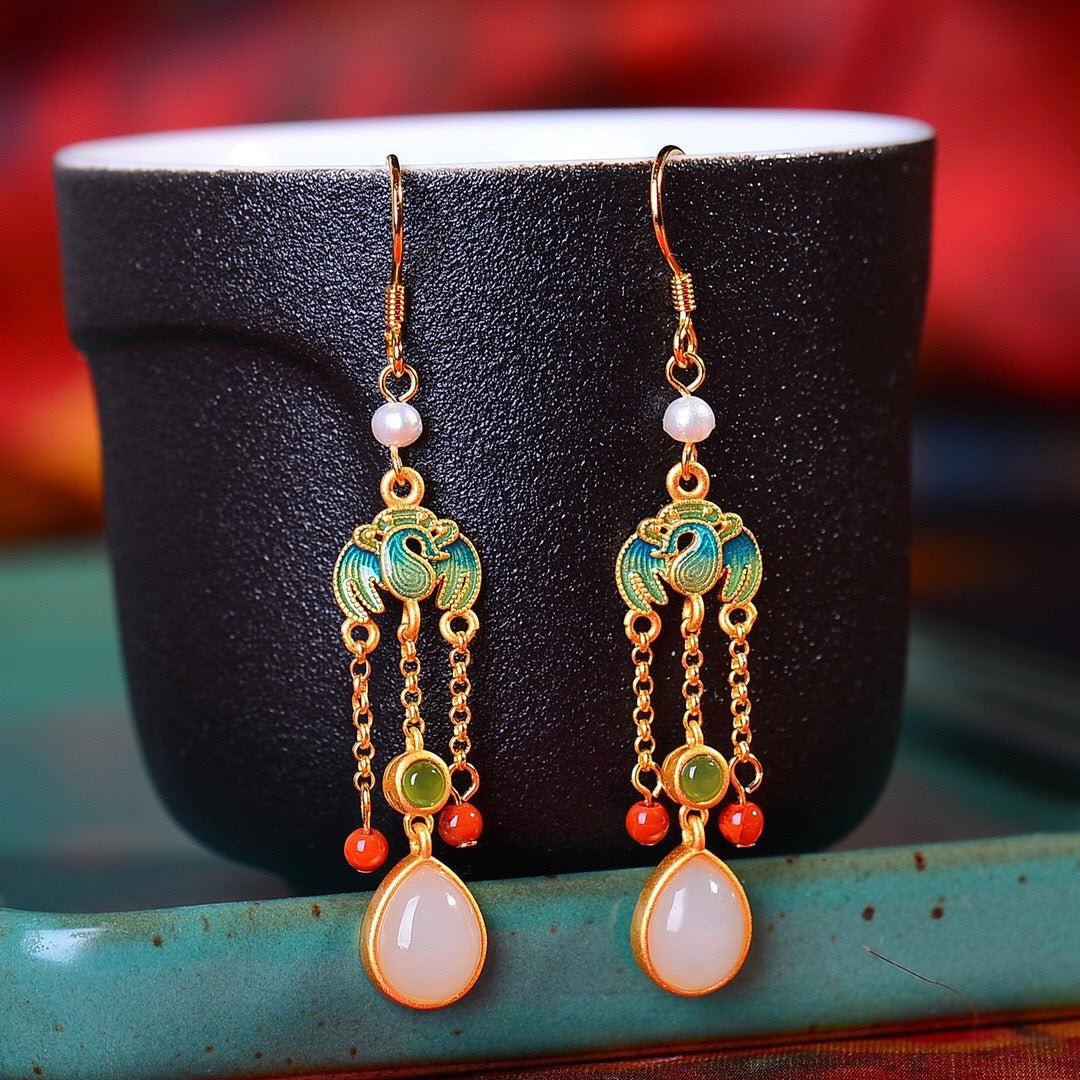 Handcrafted dangle earrings with white jade drops, red and green threads, and a touch of vintage flair.