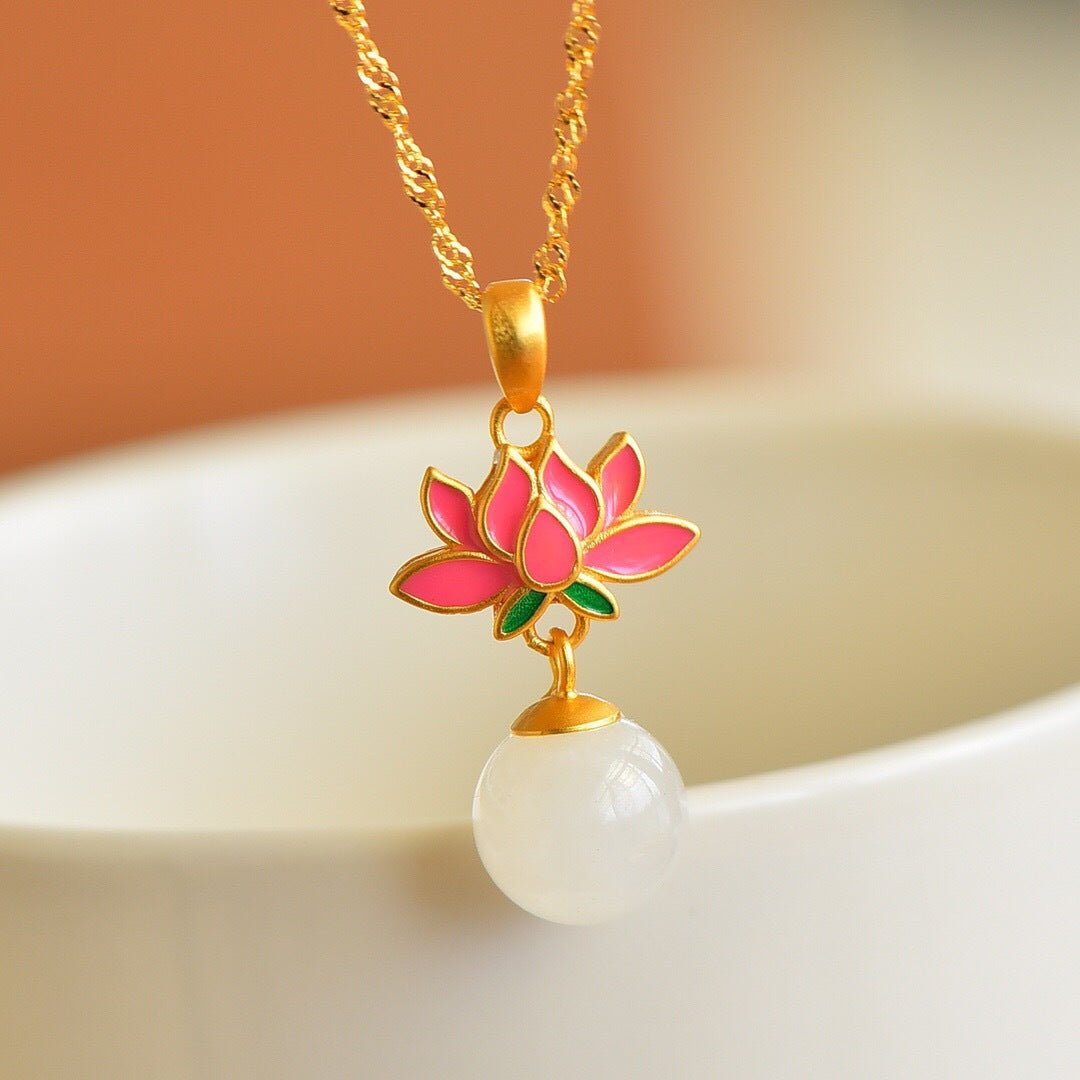 White jade and gold lotus pendant resting softly on a porcelain dish – delicate and serene